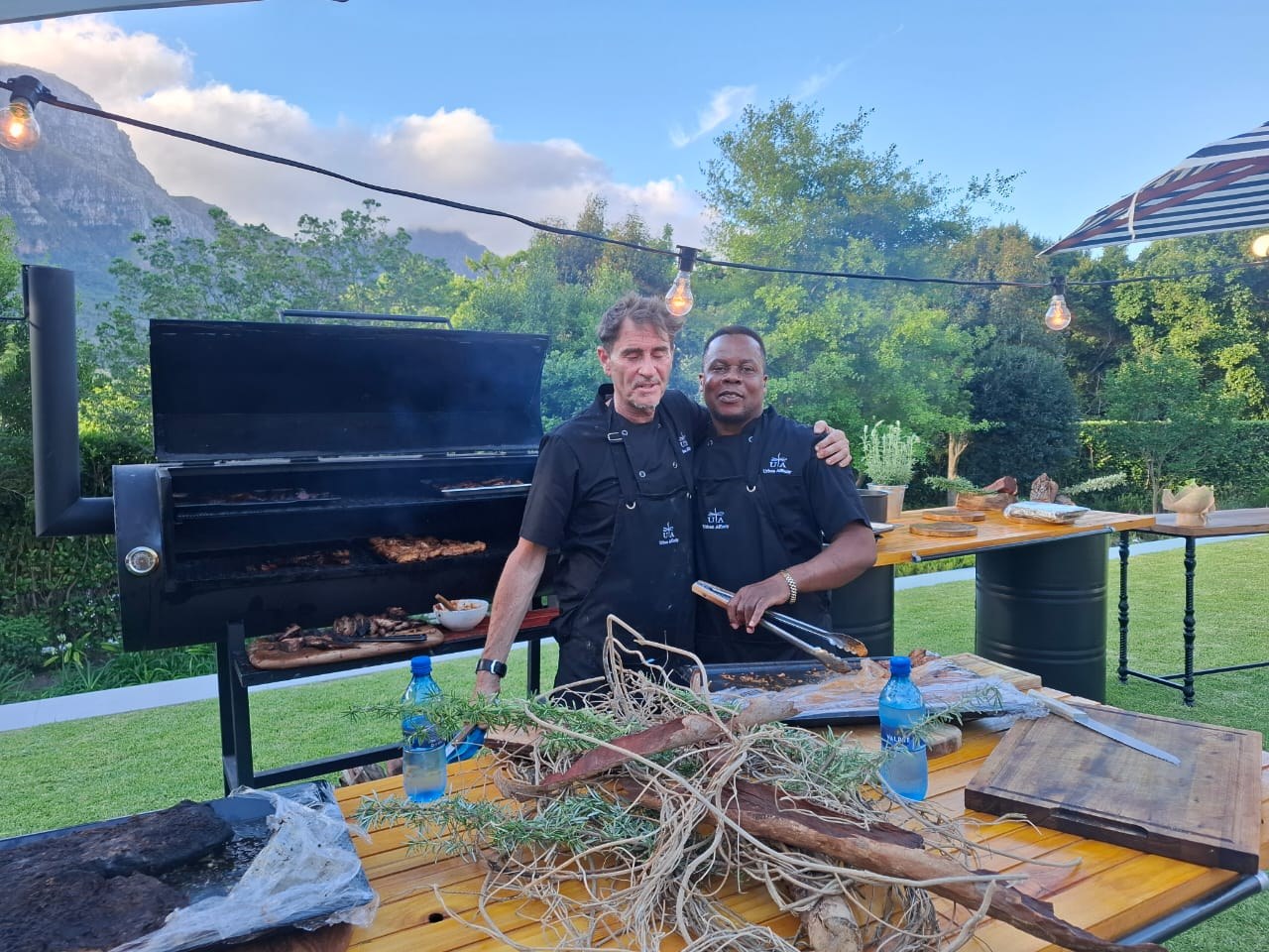 Chefs beside the BBQ smoker
